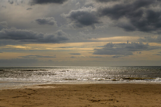 An autumnal HDR seacape image of Fleetwood beach with calm seas, hazy sun and solitude, Lancashire, England.