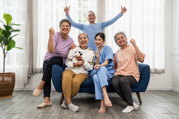 Group of Asian elderly people in a nursing home with young caregiver.