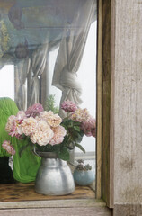 Fototapeta na wymiar Vintage rose vase in the corner of the wooden window