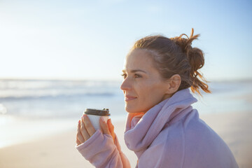 relaxed elegant woman in cosy sweater at beach in evening