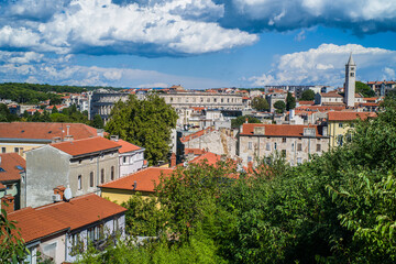 old, colorful houses and narrow streets in the center of the old town of Pula. In the background, port oddities