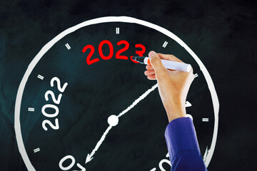 businessman hand writing 2023 number on the clock