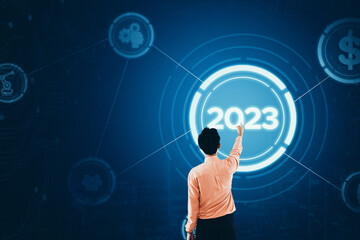 Businessman touch 2023 button on virtual screen