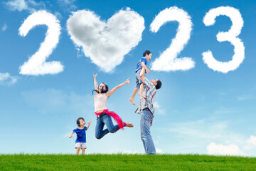 Family with 2023 number and heart symbol at park