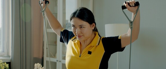 A little overweight Asian Korean female working out at home, catching breath after exercise