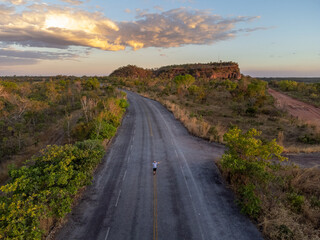 a man in the middle of the road in the forest