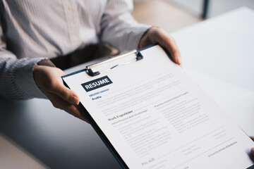 Businesswoman Holding Resume,Examiner reading a resume during job interview at office Business and human resources concept.