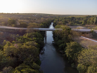 beautiful and narrow river in the low vegetation forest with the rising sun