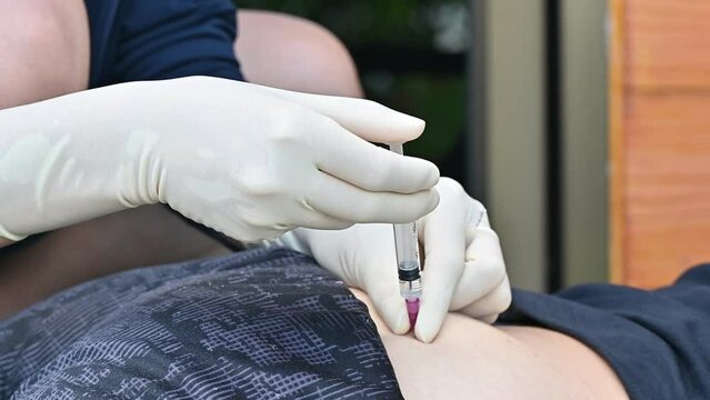 Healthcare worker doing an intramuscular injection to patient gluteus muscle.