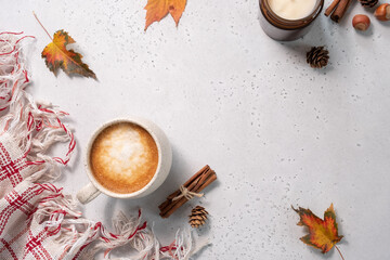 Autumn composition. Cup of coffee, blanket, autumn leaves, cinnamon sticks on white background....