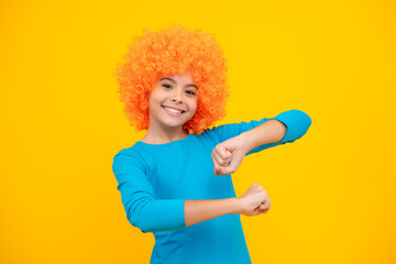 Beautiful teenage girl in wig isolated on yellow. Funny clown wig. Happy teenager portrait. Smiling girl.