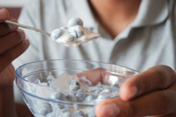 Fototapeta na wymiar men eating yogurt with blue berry in a bowl 