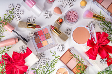 Winter and Christmas decorative make up cosmetics, artificial snowflakes, Christmas tree branches, gift boxes, beauty accessories.  Christmas and New Year winter cosmetics sale flat lay on white backg