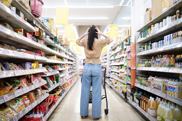 スーパーマーケットで頭を抱える女性