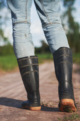 farmer wears boots walking on the path, farming concept, cultivation and agriculture