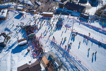 Aerial view of a crowd of people in turn in the ski lift station