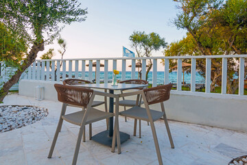 Obraz premium Tables in restaurant on the terrace . Zakynthos, Greece. Superb summer mood, outdoor restaurant. Romantic vibes, summer colors under blue sky