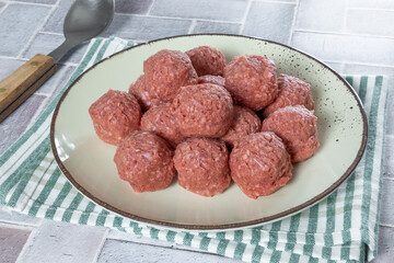 boulettes de boeuf cru dans une assiette	