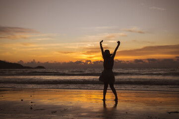Fototapeta premium Silhouette of woman in hat on Enjoying Beautiful Sunset on the Beach