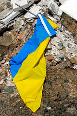 Ukrainian flag in the ruins of a demolished house