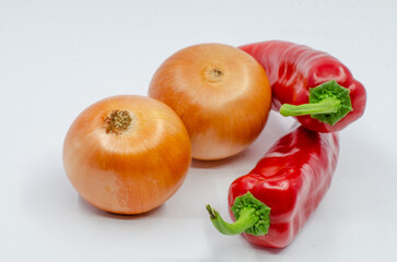 Red hot pepper and onion on a white background. Onions and hot peppers prepared for food on a white isolated background.
