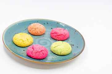 Colorful cookies in a blue plate. Colorful cookies on a white isolated background.
