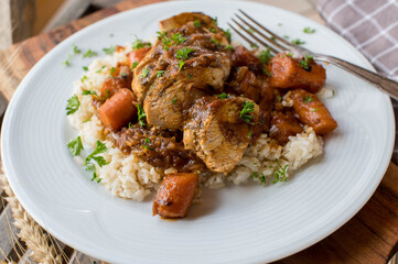 Stew chicken breast with brown sauce and vegetables on a plate