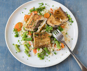 Healthy fish dish with brown rice, vegetables and salmon fillet