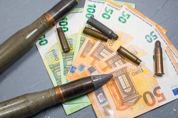 Euros money, bullets, shells, cartridges and projectiles on gray background. Lend-Lease concept.  Army concept. Sales of weapons and ammunition. Military industry, war, global arms trade.