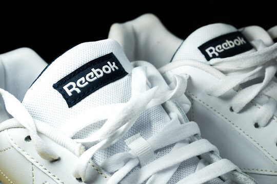 KYIV, UKRAINE - June 20, 2022 : Modern Reebok Classic Leather sneakers on the yellow background. White leather trainers on yellow sole. Close up.
