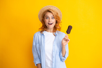 Summer concept. Glad positive woman holds tasty frozen ice cream, enjoys eating delicious cold dessert, poses on yellow background, feels fun Amazed surprised woman face.