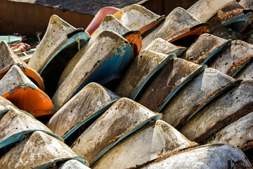 Old boats stacked on land with wear from time