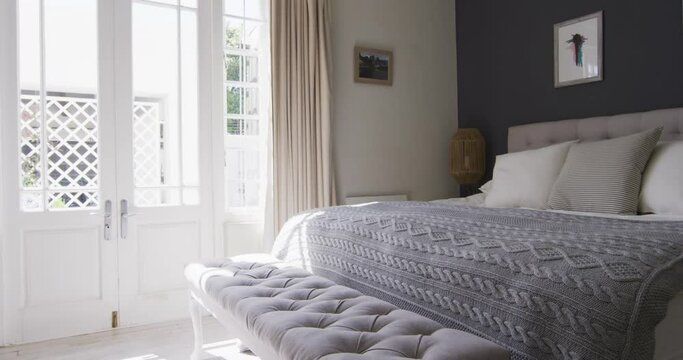 General view of bedroom interior with bed and big window