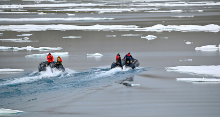 Zodiac boats making her way through the Arctic sea with a floe of melting ice, against picturesque...