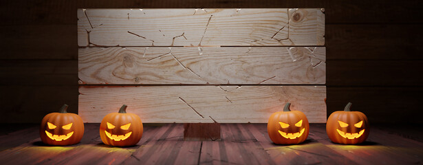 Halloween pumpkins and empty wooden signboard on table. Carved eyes glowing
