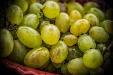 A close-up photo of white grapes in a red bowl