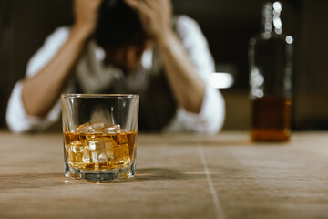 Whiskey glass A young man is drunk unconscious with a whiskey glass at the table.