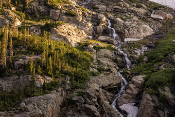 Fototapeta na wymiar Snowmelt Cascade Flows Through A Boulder Field In Rocky Mountain