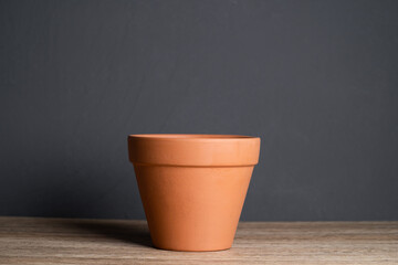 Empty terracotta pot with isolated concrete background