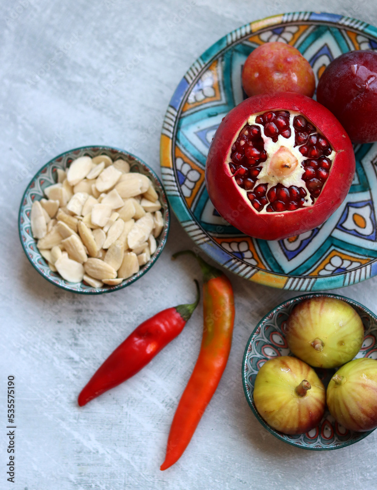 Sticker Fresh Mediterranean fruit on a blue ceramic plate. Colorful still life with pomegranate, figs, plums. Healthy eating concept. 