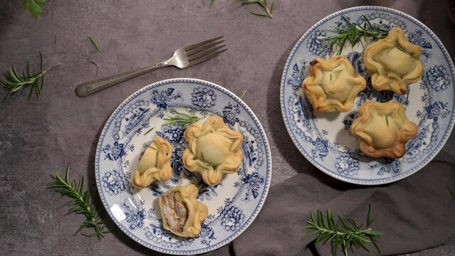 Typical portuguese snack with meat. Chicken pies know as empadas de frango or galinha on old fashioned ceramic plates.