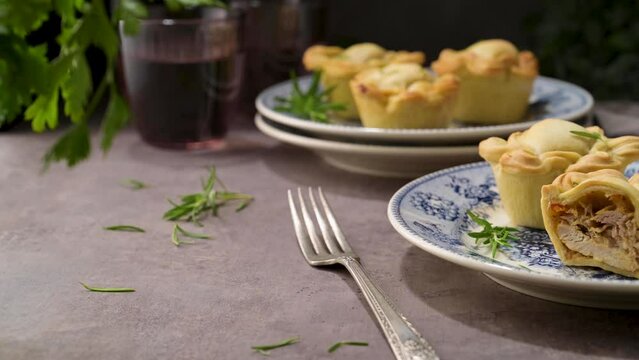 Typical portuguese snack with meat. Chicken pies know as empadas de frango or galinha on old fashioned ceramic plates.