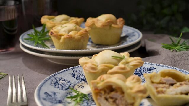 Typical portuguese snack with meat. Chicken pies know as empadas de frango or galinha on old fashioned ceramic plates.
