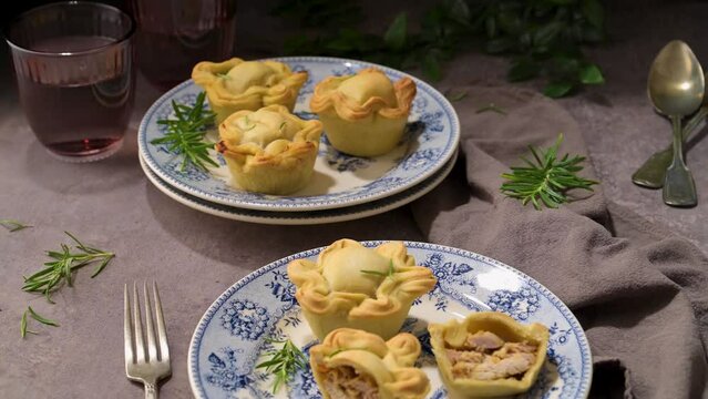 Typical portuguese snack with meat. Chicken pies know as empadas de frango or galinha on old fashioned ceramic plates.