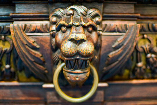 A fragment of an interior item made of wood with the image of a lion