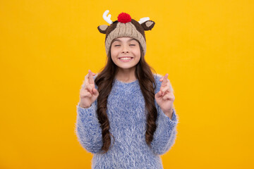 Modern teenage girl 12, 13, 14 year old wearing sweater and knitted hat on isolated yellow background.