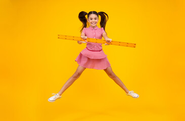 Teenager school girl study math or geometry lesson, measure the size. Mathematics ruler for measuring. Crazy jump, jumping kids. Happy positive and smiling schoolgirl.