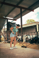 Fototapeta premium Young farmer girl pushing the calves feed with the brush