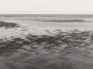 Wet sand. Gloomy landscape. The nature of the Europe. The coast of the Atlantic. Gray sand - Powered by Adobe