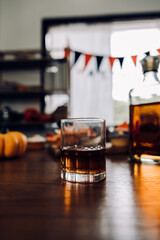 a glass of whiskey on wood bar, soft focus.	